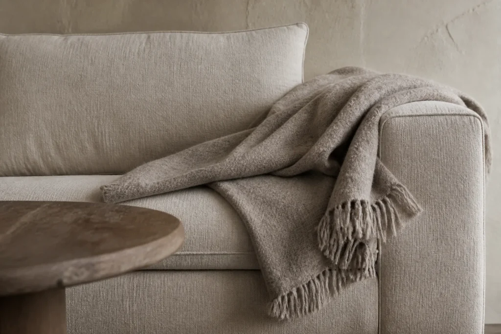 Architectural close-up of linen, wool, plaster and wood textures in a luxury living room